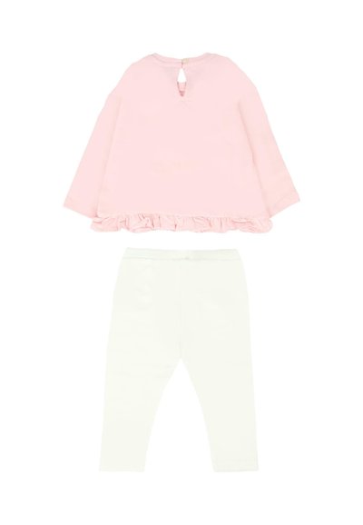 Roze langesleeve top met een gerimpelde rand en een sleuf achteraan, gecombineerd met witte leggings, beide gemaakt van zachte, rekbare stof.