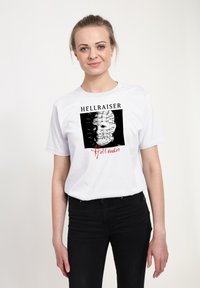 Hvid bomulds t-shirt med et sort grafik af et maskeret ansigt, mærket "HELLRAISER" og "Hell seeker" i sort og rød tekst.