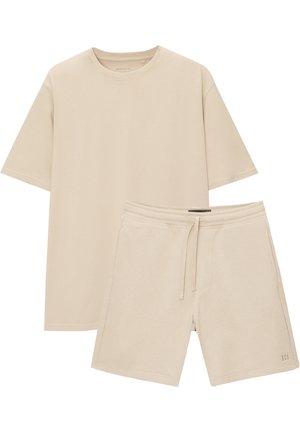 Beiges T-Shirt mit kurzen Ärmeln und Rundhalsausschnitt, kombiniert mit passenden Shorts mit Kordelzug, beide aus weichem, bequemem Stoff.