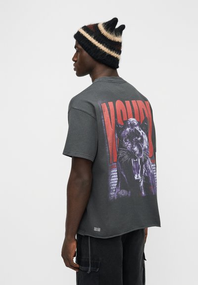 Γκρι γραφικό t-shirt με μεγάλο σχέδιο πάνθηρα και έντονο κόκκινο κείμενο στην πλάτη. Βαμβακερό ύφασμα, άνετη εφαρμογή, στρογγυλή λαιμόκοψη, κοντά μανίκια.