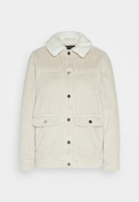 Chaqueta de pana beige con cuello de piel sintética, dos bolsillos en el pecho, dos bolsillos inferiores y botones a presión plateados. Tejido texturizado con líneas verticales.