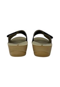 Sandali platform neri senza lacci con suola beige testurizzata. Il design con retro aperto presenta un tallone curvo e una soletta morbida. Stile semplice e funzionale.