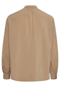 Beige langærmet bluse med højt hals, blød tekstur og plisseret detalje bagpå. Har knapmanchetter og en løstsiddende pasform.