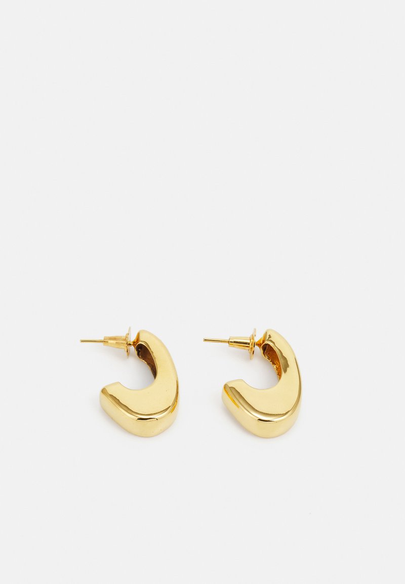 Boucles d'oreilles en or avec un design minimaliste et courbé. Surface polie reflétant la lumière, dotée d'un système de fixation à tige sécurisée.