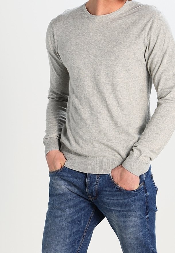 Helles grauer Langarm-Pullover mit Rundhalsausschnitt aus weichem Material, kombiniert mit blauen Jeans. Verfügt über gerippte Bündchen und Saum.