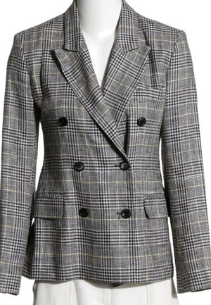 Blazer gris à carreaux croisé avec boutons noirs, revers crantés et poches à rabat sur un buste de mannequin blanc.