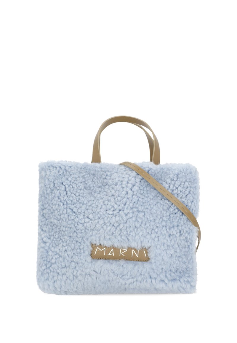 Borsa a tracolla in finta pelliccia blu chiaro, con forma rettangolare, manici corti e una tracolla rimovibile di colore tan. Presenta un'etichetta con logo.