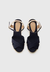Mörkblå espadrille-sandaletter med korsade tygremmar, justerbar vristrem och en jute-wrapped kilklack.