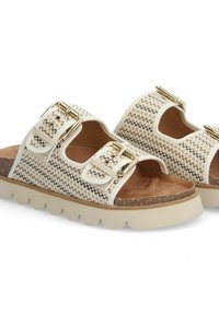 Twee instap sandalen met een geweven patroon in beige en bruin, voorzien van twee verstelbare gespen en een gevoerde voetbed. Lichtgewicht platformzolen.