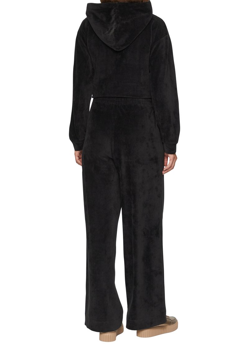 Czarny dres z weluru z krótką bluzą i szerokimi spodniami. Posiada miękką fakturę i elastyczny pas dla zapewnienia komfortu.