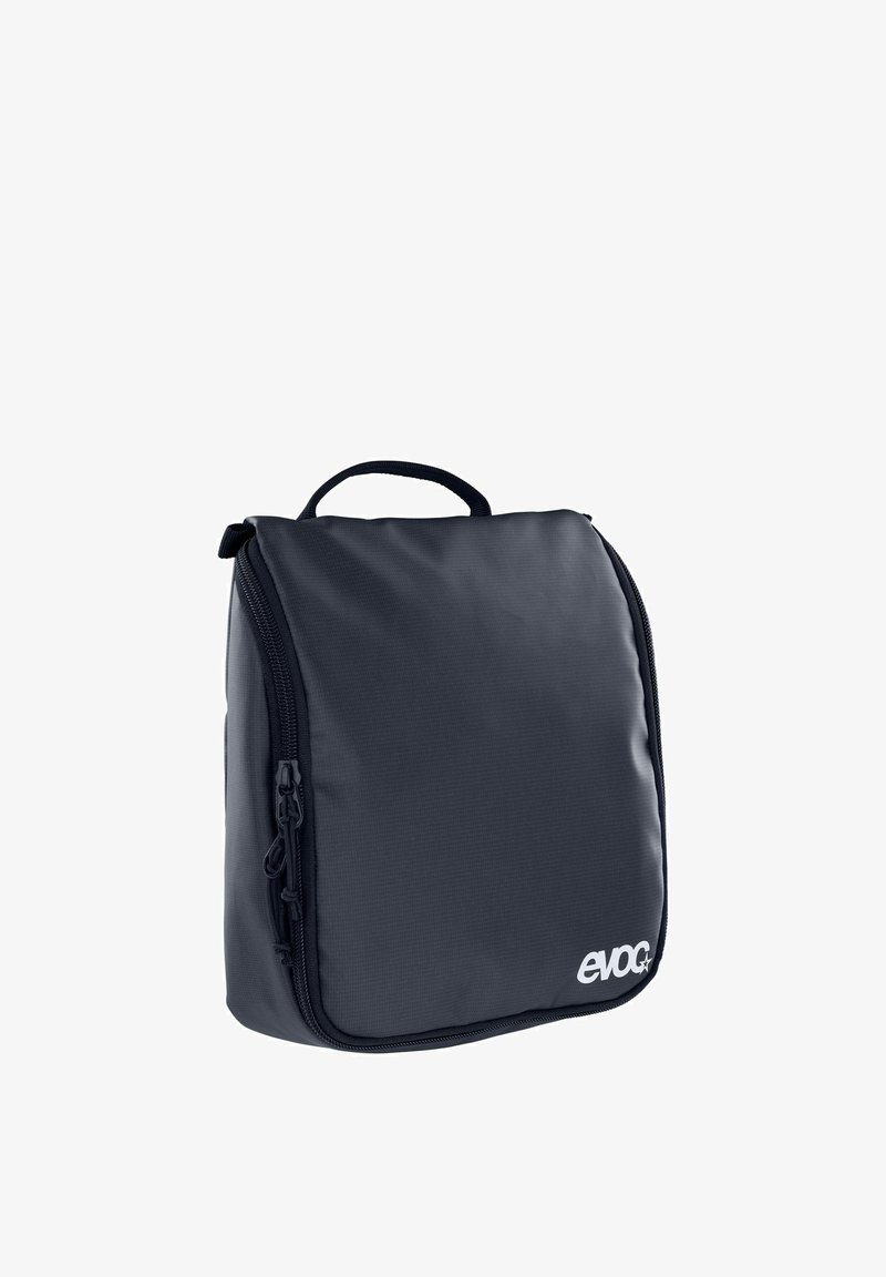 Borsa da viaggio blu scuro con esterno morbido e strutturato, chiusura con zip e manico superiore per il trasporto; presenta il marchio sulla parte anteriore.