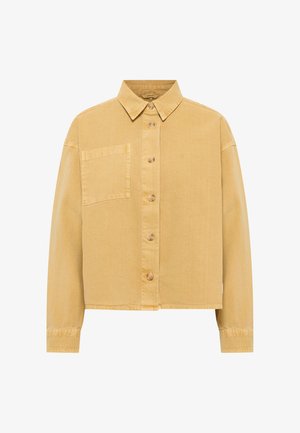 Sárga farmering gombos elülső résszel, széles nyakkal, egyetlen mellzsebbel és hosszú ujjakkal. Fapróbák jellemzik, valamint rövidített fazonja van.