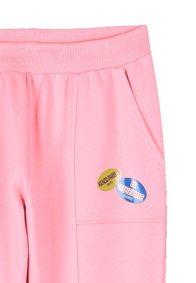 Roze joggingsbroek met een geribbelde tailleband, zijzakken, voorzien van twee ronde stoffen labels met "KENZO PARIS 1970" en "18 VIVIENNE PARIS."