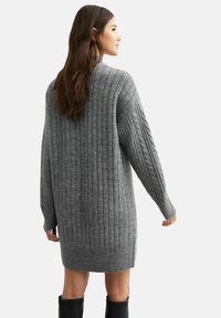 Abito maglione grigio a maglia con una texture a coste, vestibilità oversized e maniche lunghe, con spacchi laterali e orlo arrotondato.