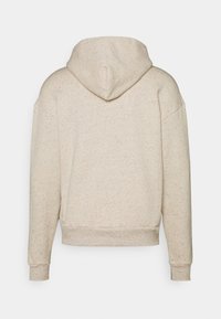 Sudadera con capucha beige jaspeada, con cordón ajustable, hombros caídos y puños acanalados. Tela de textura suave con un corte holgado.