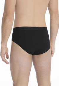 Black cotton briefs with a smooth texture and a mid-rise waist. The waistband features branding and has a snug fit.