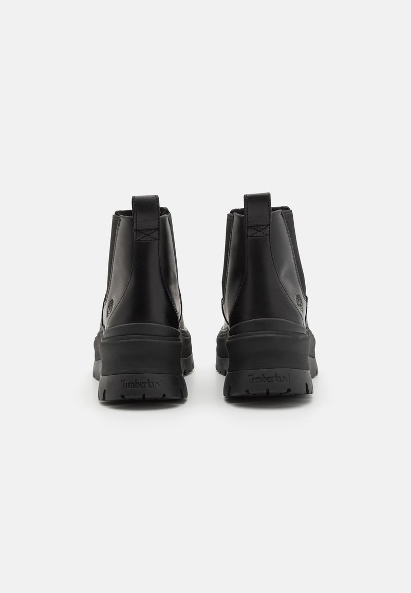 Czarne skórzane botki za kostkę z zaokrąglonym noskiem, minimalnym przeszyciem, pętlami do zakupu oraz gumowymi podeszwami, z logo "Timberland" na pięcie.