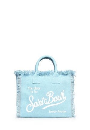 Sac fourre-tout en tissu bleu clair avec bords frangés et texte blanc indiquant "The place to be Saint Barth Summer Paradise" à l'avant.