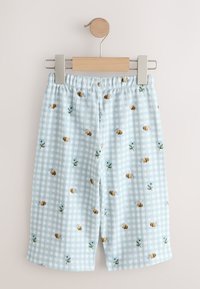 Shorts à carreaux bleu clair avec imprimé d'abeilles et de petites fleurs, suspendus sur un cintre à clip en bois et métal sur fond blanc.