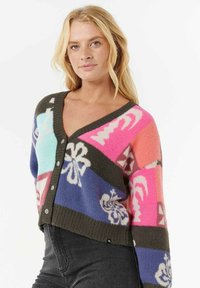 Bunte Strickjacke mit V-Ausschnitt, die geometrische und florale Muster in Pink, Blau, Lila und Braun zeigt. Fünf Knopfverschluss.