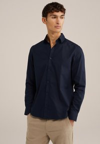 Temno modra dolga srajca z gumbi iz gladkega bombažnega materiala, z običajnim ovratnikom in elegantnim sprednjim zapenjanjem.