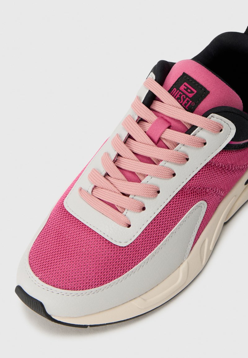 Sneakers en maille et cuir rose avec des lacets rose clair, accents noirs et semelle en caoutchouc blanche ; dessus texturé et détail de langue de marque.