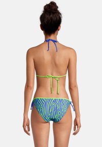 Twee-delige bikini met een blauwe halternek en groene strikjes, en een onderkant met een blauw en groene zebra-strepenpatroon. Soepele, rekbare stof.