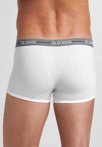 Boxer in cotone bianco con elastico grigio in vita con la scritta "SLOGGI" in bianco. Texture liscia e design aderente.