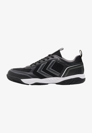Zapatilla deportiva negra y gris con parte superior de malla, cierre de cordones en la parte delantera, entresuela blanca y dos franjas grises en chevrón en el lateral.