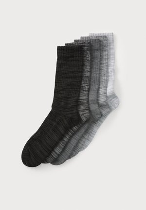 Quatre paires de chaussettes de longueur cheville dans des nuances dégradées de noir, gris foncé, gris clair et blanc, avec un motif texturé et côtelé.
