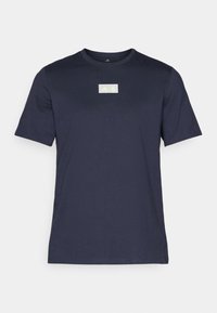 Camiseta de manga corta azul marino hecha de tela suave, con un logo rectangular en amarillo claro en la parte superior del pecho.
