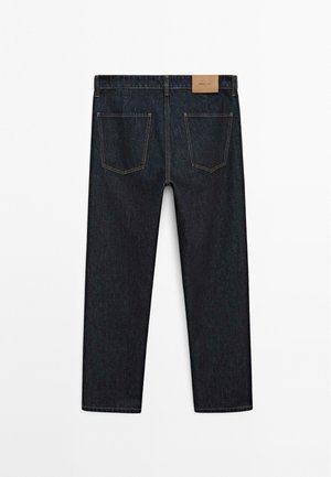 Dark blue denim jeans displayed from the back, featuring two back pockets and a rectangular brand label at the waistband.
