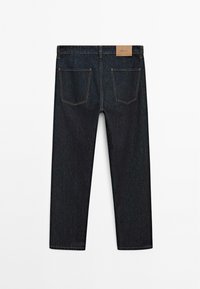 Mørke denim jeans med lige pasform, der har to baglommer og et tan lædermærke i taljen.