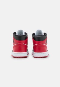 Zapatillas altas con parte superior de cuero rojo, acentos negros, mediado blanco y suela texturizada. Presentan el logotipo distintivo en la parte posterior.