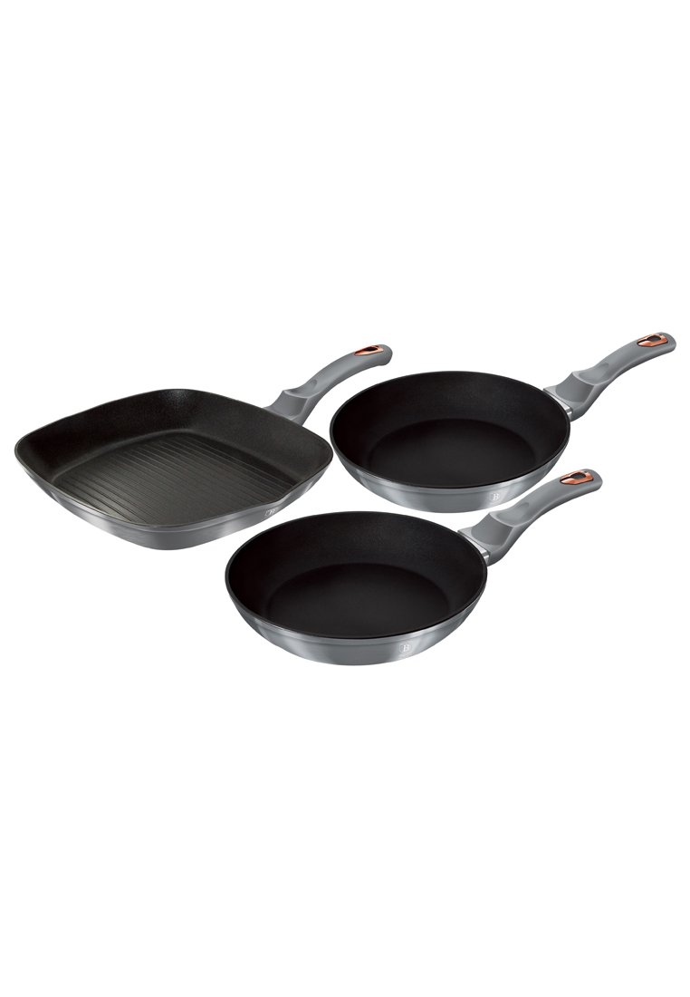 Tres sartenes antiadherentes: dos redondas de color negro con mangos grises y una sartén cuadrada con superficie acanalada, todas con bordes suaves.