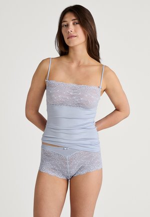 Lichtblauwe cami met kant aan de bovenkant en bijpassende kant korte broek. Voorzien van dunne spaghettibandjes en een gladde textuur.