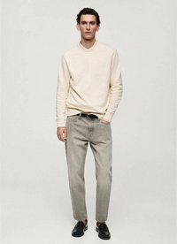 Beige sweatshirt with ribbed cuffs, gray straight-leg jeans, and black shoes. Simple design with subtle stitching details and a relaxed fit.