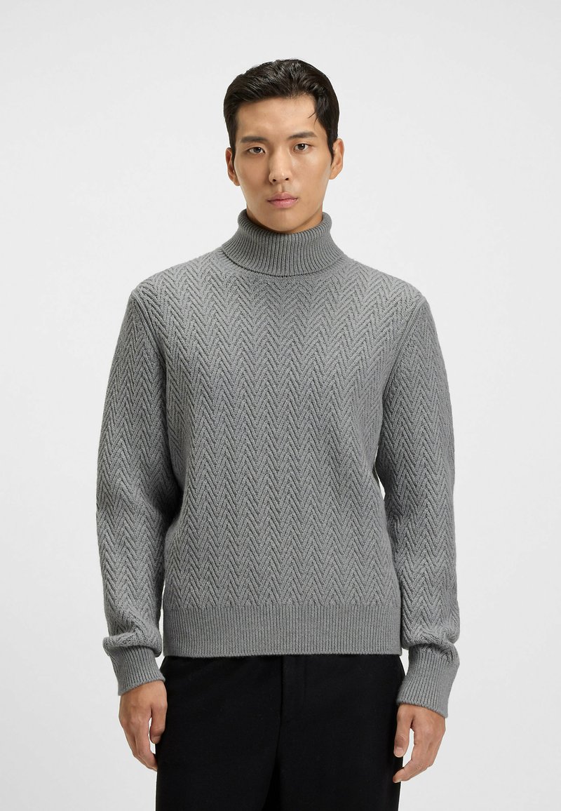 Grauer Rollkragenpullover mit Fischgrätmuster, geripptem Kragen und Bündchen, aus strukturiertem Strickmaterial. Lange Ärmel, lockere Passform.
