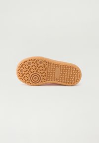 Rubber shoe sole featuring a textured surface, geometric patterns, circular accents, and branding. Predominantly orange color.