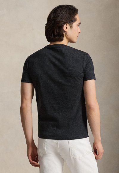 Kortermet T-skjorte med rund hals i mørkegrått stoff. Klassisk passform med glatt tekstur og minimal søm-detalj ved halskanten.