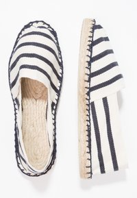 Leinensandalen mit schwarz-weißen horizontalen Streifen, Seilsohle und gestickten Kanten, entworfen für den Freizeitbereich.