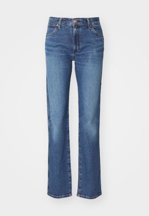 Ausgestellte blaue Denim-Jeans mit mittelhohem Bund, subtiler Verwaschung und einem rohen Saumdetail. Hergestellt aus strapazierfähigem Baumwollstoff.