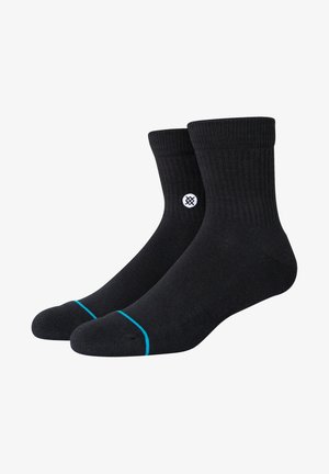 Black cotton socks with a ribbed texture, featuring a white logo on the side and a blue accent at the toe. Mid-calf length design.