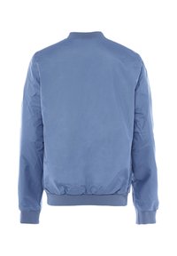 Šviesiai mėlynas bomber tipo švarkas, pagamintas iš lygaus nailono. Riešo apykaklė ir rankogaliai yra su guma, o liemuo surinktas. Nėra matomų prekės ženklų.