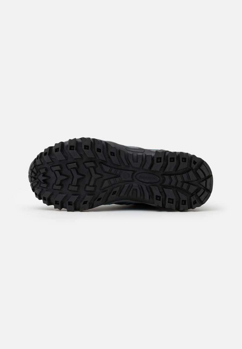 Suela de zapato de goma negra con un diseño de banda de rodadura resistente. Presenta profundos surcos y pernos para una mejor tracción. Contorno liso a lo largo de los bordes.