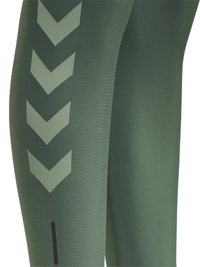 Olijfgroene leggings met een gladde textuur, voorzien van grote chevronpatronen in een lichter groen aan de zijkant en een klein zwart ritsdetail.