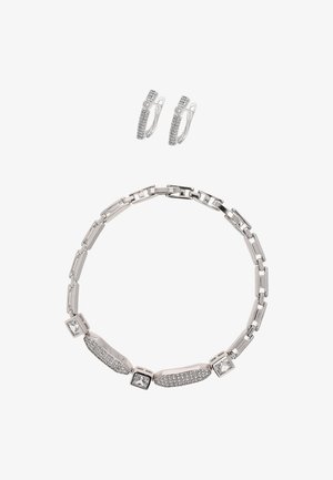 Collana a catena d'argento con maglie geometriche e dettagli in zirconi cubici, abbinata a orecchini a cerchio coordinati con decorazioni in pietre trasparenti.