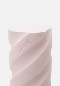 Gedraaide schuimroller in zachtroze, met een gestructureerd oppervlak en gegraveerd "casall" logo. Cilindervorm met een platte bovenkant.