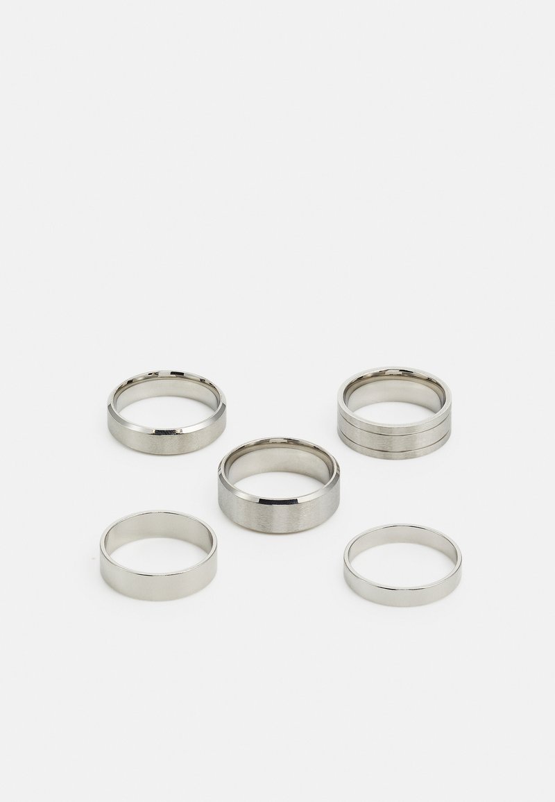 Sæt af fem metalliske ringe i forskellige bredder, med glatte, polerede og børstede overflader; farverne spænder fra skinnende sølv til mat.