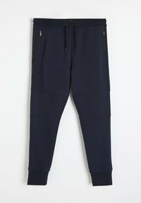 Granatowe joggery wykonane z miękkiego materiału, z tapered nogawkami, elastycznym pasem ze sznurkiem i zamykanymi kieszeniami bocznymi. Teksturowane panele po bokach.